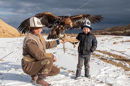 Biosphoto | 2551392 | Aiglier kirghize (Berkutchi) portant un Kalpak, présentant son aigle accompagné de son petit-fils, Kirghizistan | &copy; Bastien Chaix / Biosphoto
