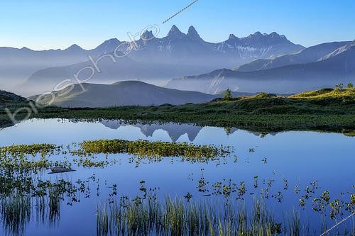 Biosphoto | 2610254 | Aurore sur le lac Guichard, au col de la Croix de Fer, en Maurienne, Savoie, Alpes, France. Des trèfles d'eau et des joncs colonisent ce lac peu profond situé à plus de 2000 mètres d'altitude en Savoie. A l'horizon, les 3 emblématiques Aiguilles d'Arves. | &copy; Jean-Philippe Delobelle / Biosphoto