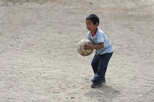 Biosphoto | 2480079 | Boy playing with a ball, Inuit settlement of Tiniteqilaaq, Sermilik Fjord, East Greenland, Greenland, North America | &copy; Olaf Krüger / imageBROKER / Biosphoto