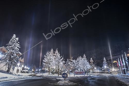 Biosphoto | 2418619 | Colonnes lumineuses, piliers de lumière ou light pillars au dessus des Gets (Haute-Savoie). Lors de la nuit très froide (-11°C) du 13 décembre 2018, la présence de cristaux en suspension au dessus des Gets suscite des piliers lumineux au dessus de la ville. Ce phénomène n’est pas fréquent en France. Il se produit le plus souvent lors de grands froids en moyenne et haute montagne. Il peut être lié à un brouillard givrant naturel, aux canons à neige, ou aux émissions liées au chauffage au bois. | &copy; Christophe Suarez / Biosphoto