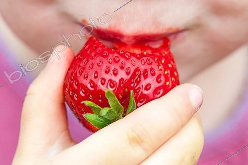 Biosphoto | 2012225 | Little girl eating a strawberry | &copy; Yann Avril / Biosphoto