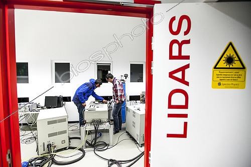 Biosphoto | 2072313 | Preparation of a Lidar laser at Maïdo,Observatoire de Physique de l'Atmosphère de la Réunion (OPAR). Reunion Island. Guillaume Payen, OPAR's technical manager, and Nicolas Marquestaut, research engineer, prepare the lasers for the night's shooting. These lidar lasers are designed to analyze certain components of the atmosphere. The Maïdo atmospheric observatory on La Réunion (one of the 3 measurement sites of the OPAR (Observatoire de Physique de l'Atmosphère de La Réunion), has been installed since October 2012 on the Piton Maïdo at an altitude of 2,200 meters. The laboratory is equipped with active and passive remote sensing instrumentation, enabling long-term, high-quality measurements of the vertical profiles of numerous climatic variables. It enables us to monitor atmospheric and climatic parameters in a context of accelerating climate change, and benefits from a unique situation in the tropical southern hemisphere, where observations are extremely rare. The observatory has 4 laser lidars, 2 of which are visible (green), and 2 invisible to the human eye. Three of the lidars are fired vertically, and one at 45 degrees, to measure wind. (i) One lidar is dedicated to measuring water vapour, with a large 1.20 m diameter telescope and two paired lasers. (ii) Three other LIDARS are designed to measure vertical profiles of atmospheric parameters (including one fired at 45 degrees, for wind measurements). The Maido observatory benefits from several major advantages. (1) Its latitudinal position for studying stratospheric transport processes. (2) Its altitude, free from pollution, humidity and light, considerably improves the quality of remote sensing measurements for studying the chemical composition of the atmosphere. OPAR's observations are part of several international observation networks, including NDACC (Network for the Detection of Atmospheric Composition Changes) and GAW (Global Atmospheric Watching). | &copy; Thibaut Vergoz / Biosphoto