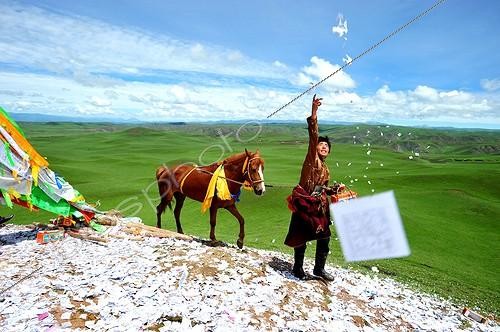 Biosphoto | 2046194 | Rider praying before the race when Lapsté - Tibet China  ; Equestrian Festival Lapste <br>Before racing, the riders and their horses are praying gods by turning around a stupa and throwing sacred papers in the air. | &copy; Antoine Lorgnier / Biosphoto