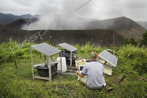 Biosphoto | 1874926 | Seismological Station of Yasur Volcano Tanna Island Vanuatu ; Sylvain Todman (geophysical engineer for the Government of Vanuatu) and Sandrine Cevuard (scientific officer volcanology) verify the proper operation of the station volcanological monitoring Yasur volcano on Tanna Island in Vanuatu. This station features a acoustimètre and buried a seismometer can be monitored in real time from anywhere in the world the volcano. This volcano, like other volcanoes in Vanuatu, is subject to continuous monitoring by the Geohazards center of Port Vila, to allow a better alert the local population in the event of imminent catastrophic eruption. The relatively large increase in explosive activity of the volcano has led to a rise in ash deposits on the island, particularly on food crops, some do not support. This is particularly the case of yam, taro and cabbage Kanak, which form the basis of the traditional diet. By Sylvain checks on his computer that measurements recorded by the station coincide well with the explosions of nearby volcano. | &copy; Thibaut Vergoz / Biosphoto