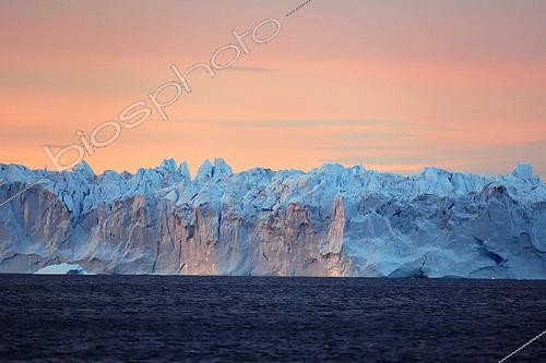 Biosphoto | 2423286 | Serac at sunset, a huge serac of a hundred meters long and 30 meters high has just detached from a glacier front at the bottom of Scoresby Sund, It will break into several large icebergs, Greenland | &copy; Pierre Vernay / Biosphoto