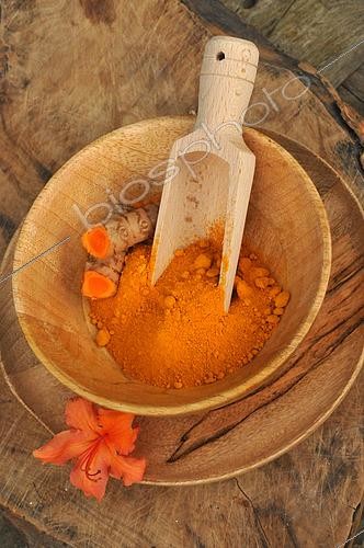 Biosphoto | 2517892 | Turmeric (Curcuma longa) spice powder and rhizome in a wooden bowl, Azalea flower as decoration | &copy; Catherine Fruhinsholz / Biosphoto